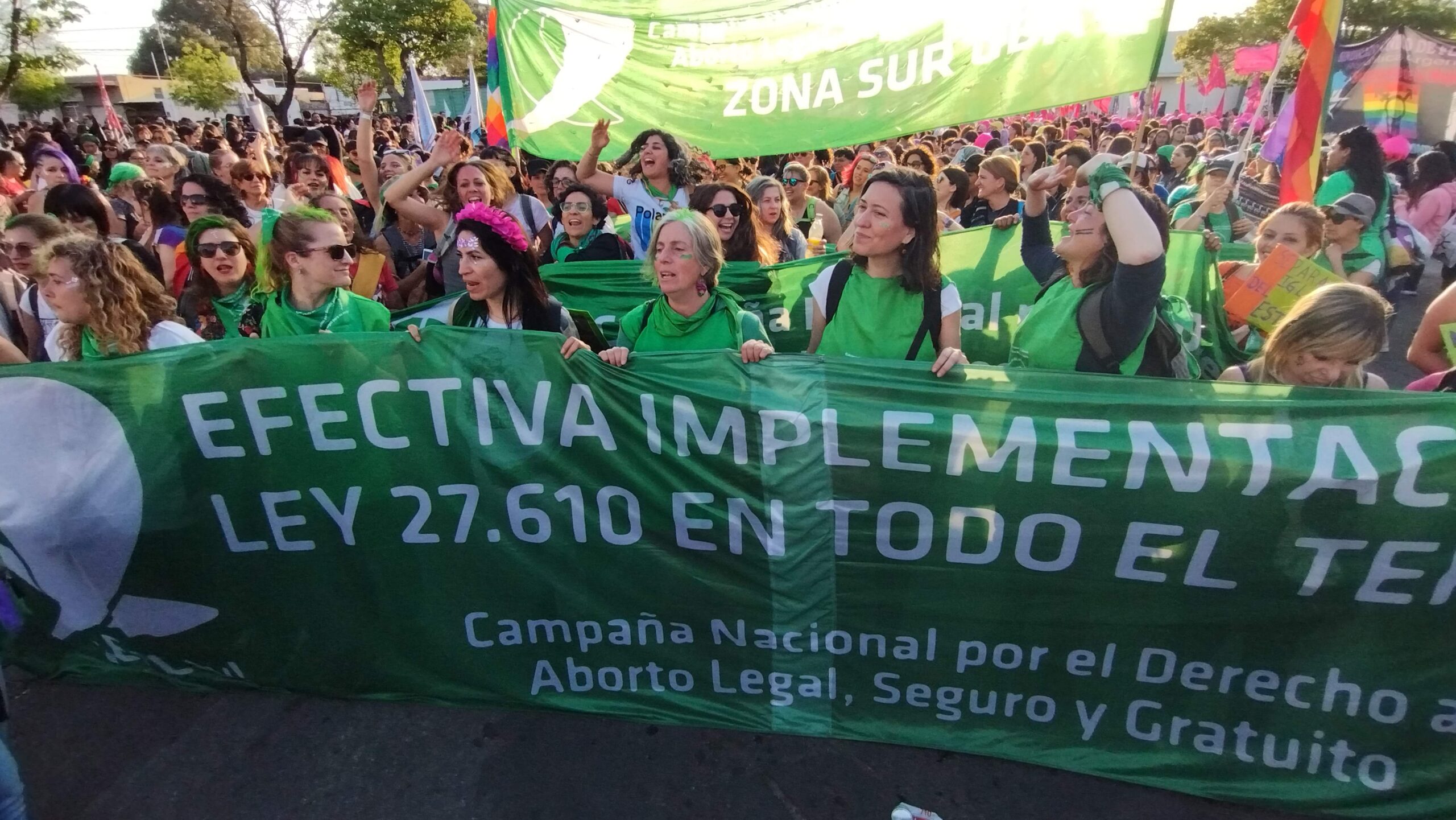 Amid a crowd of marchers, members of Campaña Nacional por el Derecho al Aborto Legal, Seguro y Gratuito in San Luis, Argentina hold up a green banner that supports the immediate implementation of law 27.610, Access to Voluntary Interruption of Pregnancy.